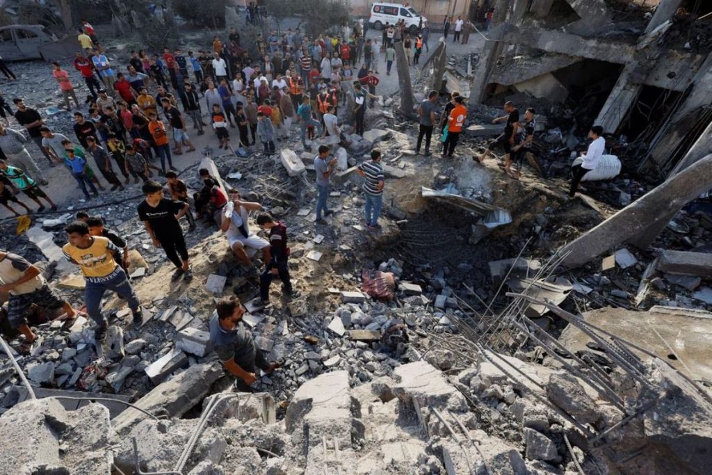 Palestinos procuram vítimas sob os escombros de um prédio destruído por ataques israelenses em Khan Younis, no sul da Faixa de Gaza, 17 de outubro de 2023. REUTERS/Mohammed Salem